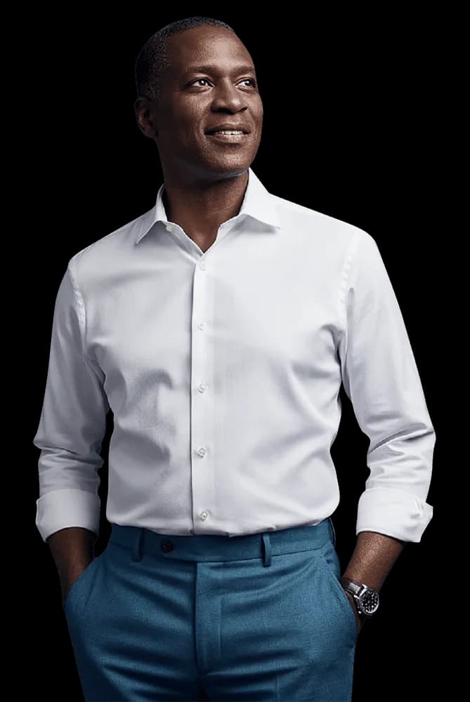 Executivo em pé com camisa branca e calça azul